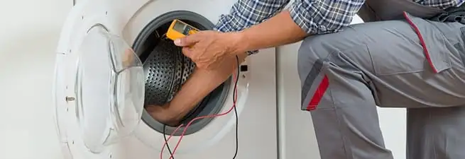 Dryer repair technician inspecting and repairing a clothes dryer in Wichita, KS