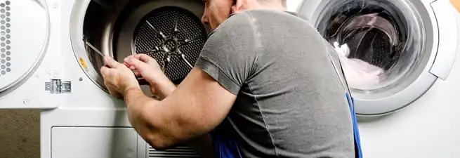 Dryer repair technician fixing a clothes dryer drum in Wichita, KS