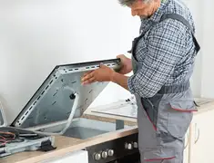 Appliance repair technician installing a built-in cooktop in Wichita, KS