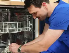 Dishwasher repair technician inspecting and servicing an open dishwasher in Wichita, KS