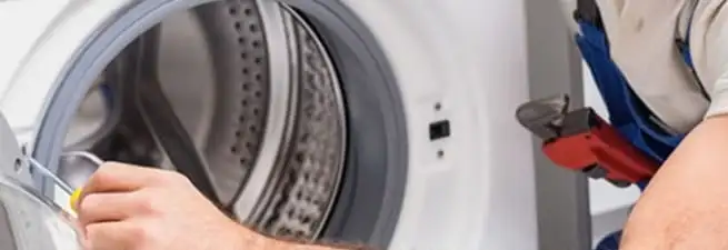 Appliance technician repairing a clothes dryer drum and internal parts in Wichita, KS