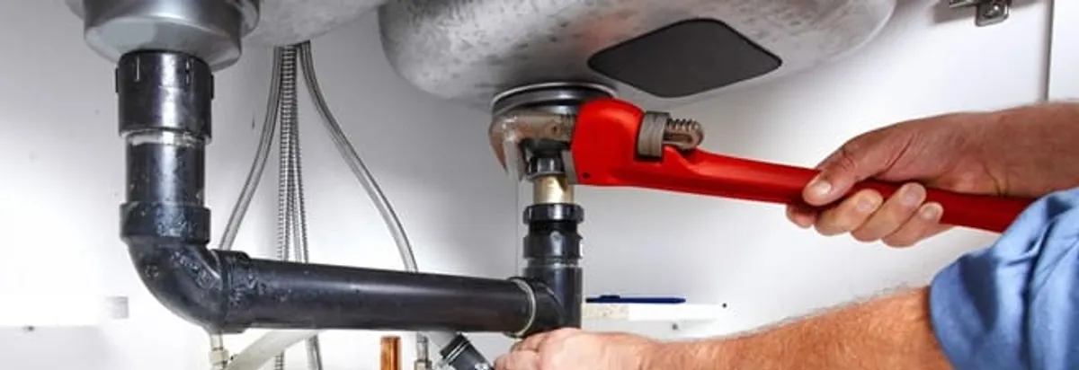 Garbage disposal repair technician tightening the sink drain and disposal connection in Wichita, KS