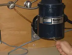 Garbage disposal repair technician tightening the mounting ring under a sink in Wichita, KS