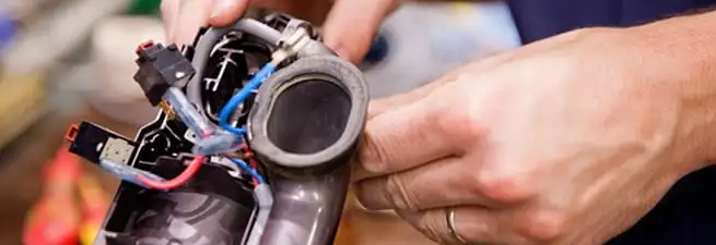 Vacuum repair technician reconnecting wiring and components in Wichita, KS