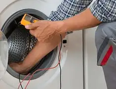 Washing machine repair technician testing a front-load washer with diagnostic tools in Wichita, KS