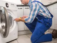 Washing machine repair technician servicing a front-load washer in Wichita, KS