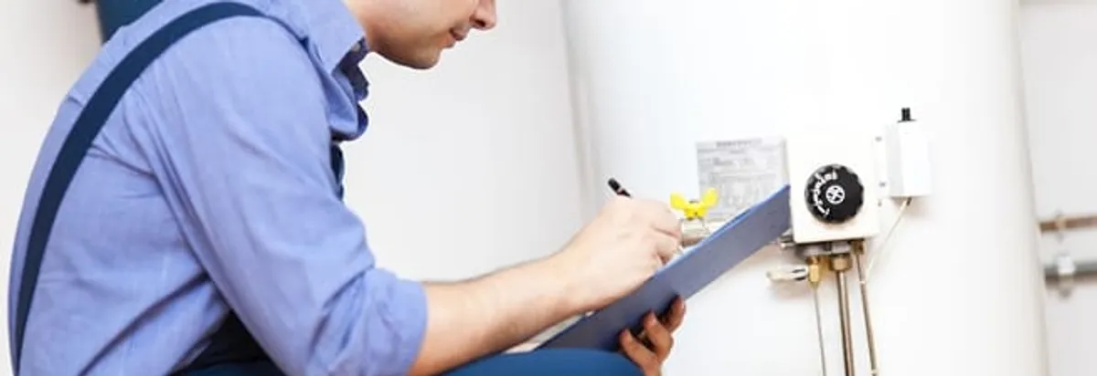 Water heater repair technician inspecting the unit and recording service notes in Wichita, KS